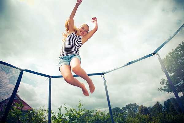 A girl jumping on a trampoline.